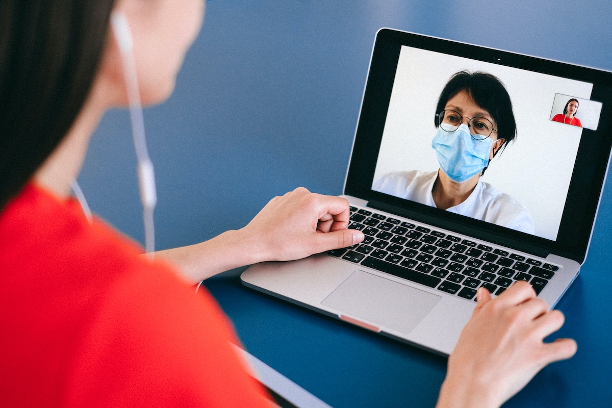 Lady on telemedicine video chat with doctor on laptop