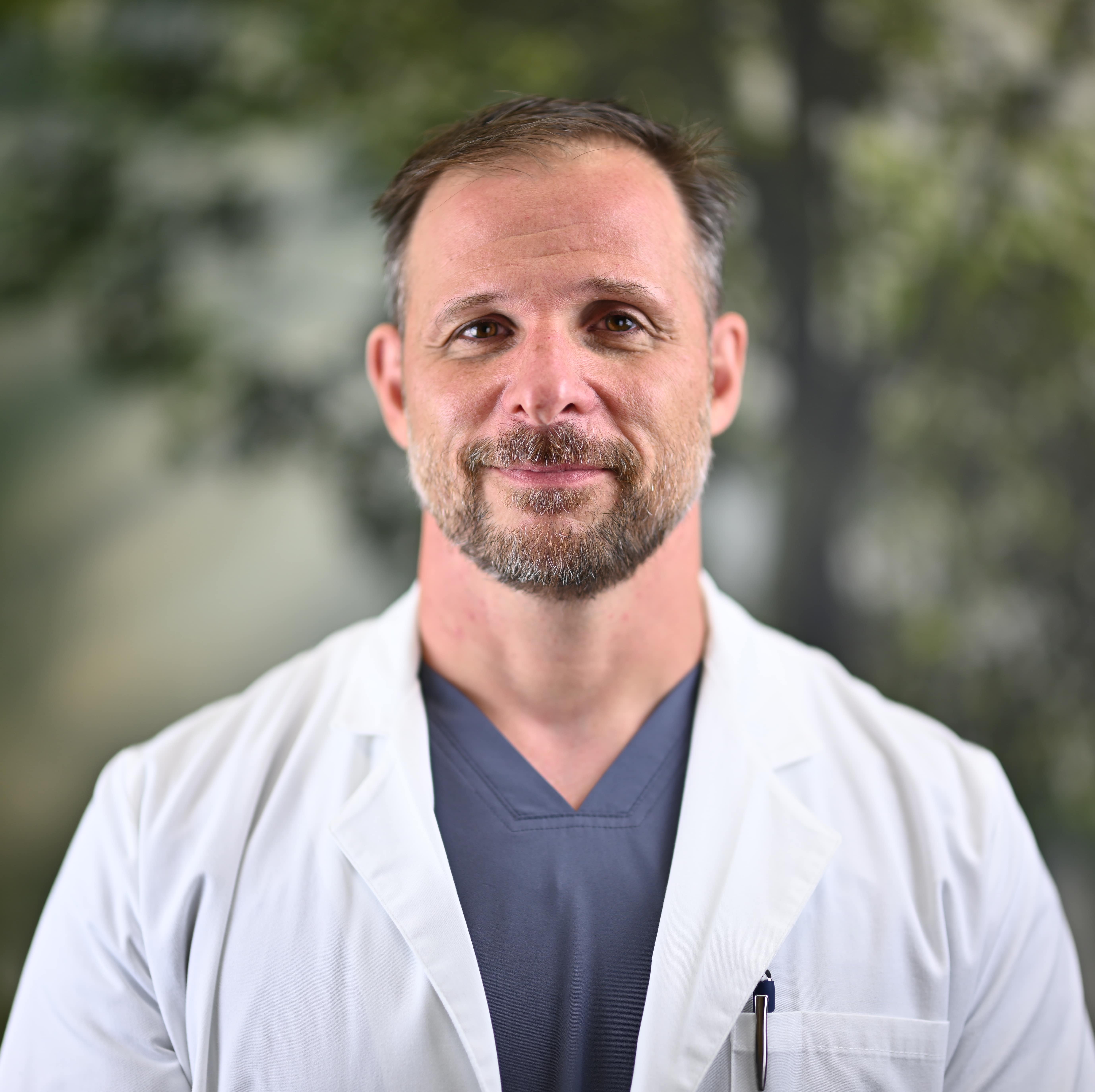 Clouse in Scrubs with lab coat